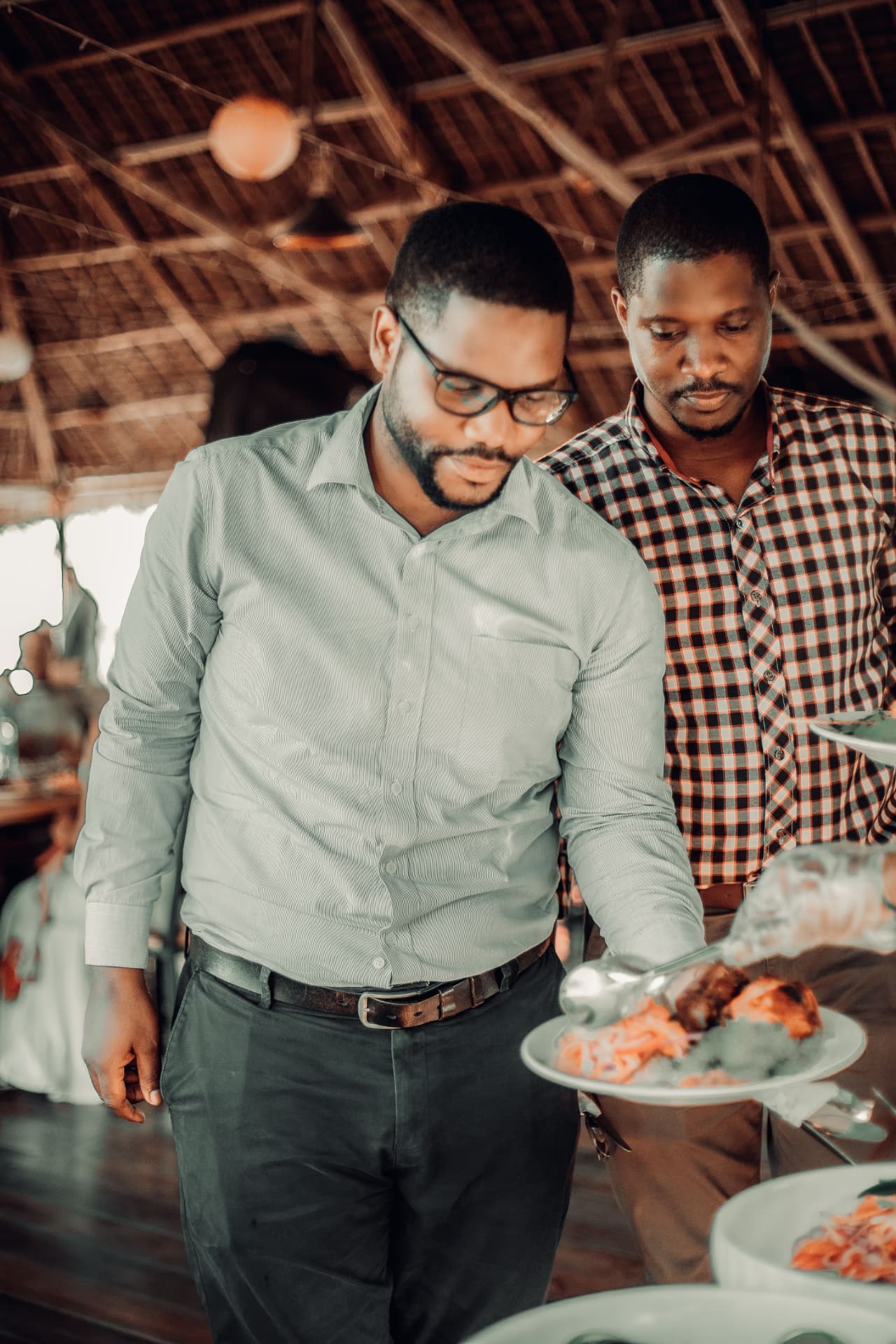 Two dads serving food together at a gathering